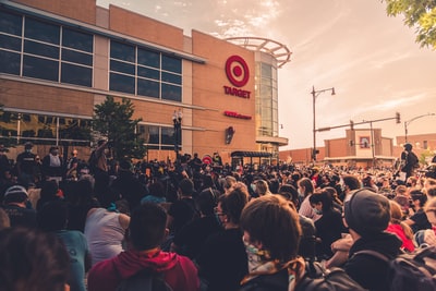 People gathered in front of the brown building during the day
